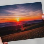 Hands-holding-a-vivid-landscape-photo-print-showcasing-standard-sizes.