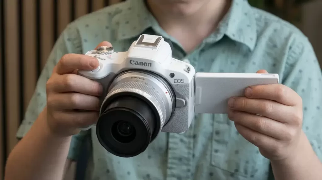 boy learning to use a real camera (Canon EOS R50)