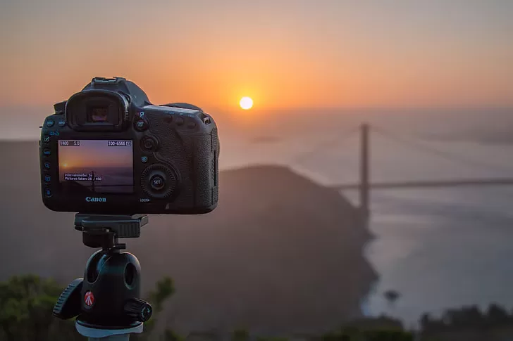 DSLR camera mounted on a tripod at sunset for landscape photography