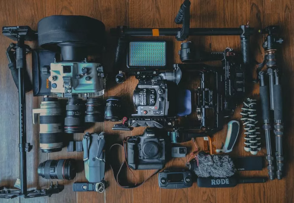 Flat lay of camera gear including a DSLR, lenses, and accessories
