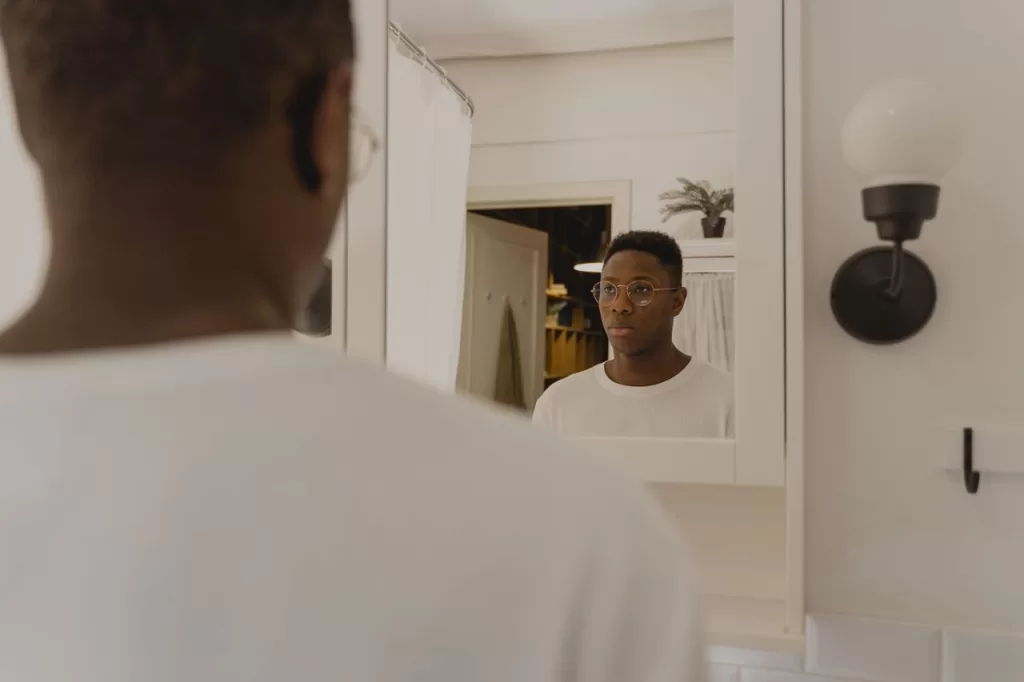 man studying his reflection in a bathroom mirror