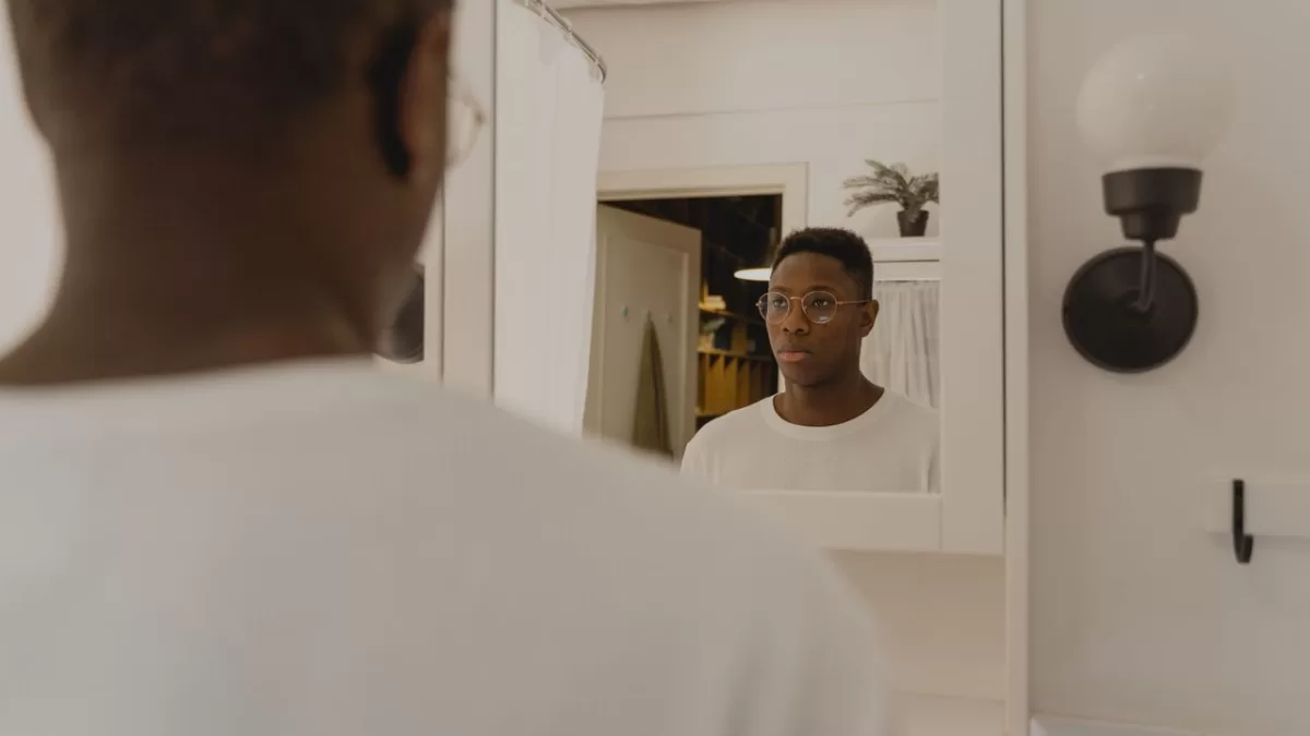 man checking reflection in bathroom mirror