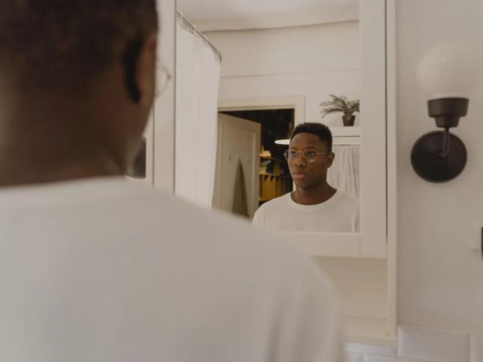 man checking reflection in bathroom mirror