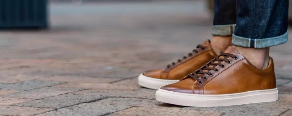 Men's brown leather dress sneakers lined up as a shoe size fit example